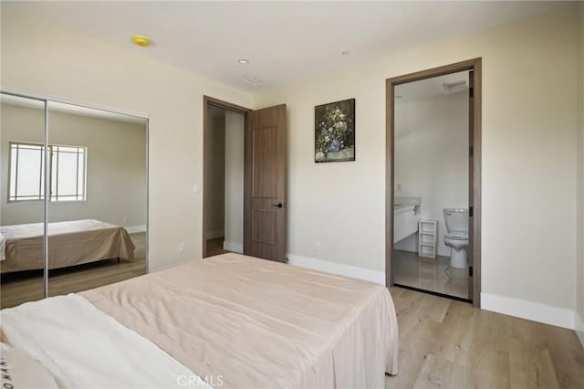 bedroom featuring light wood-type flooring and ensuite bathroom