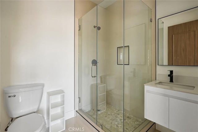 bathroom featuring vanity, toilet, and a shower with door