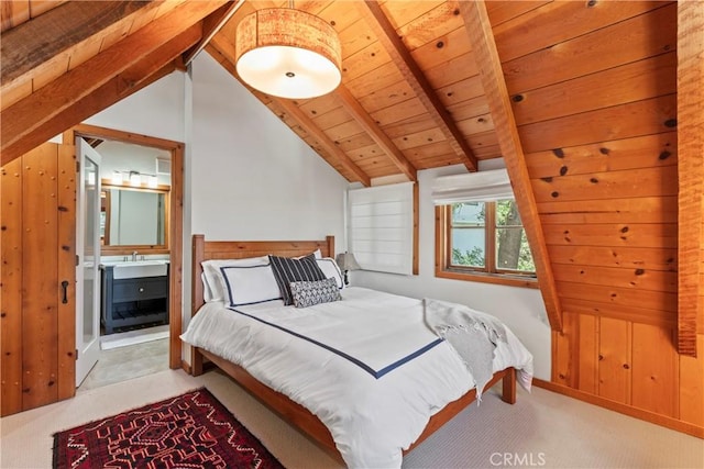 bedroom with light colored carpet, wood walls, vaulted ceiling with beams, connected bathroom, and wooden ceiling