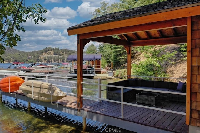 view of dock with an outdoor living space and a water view