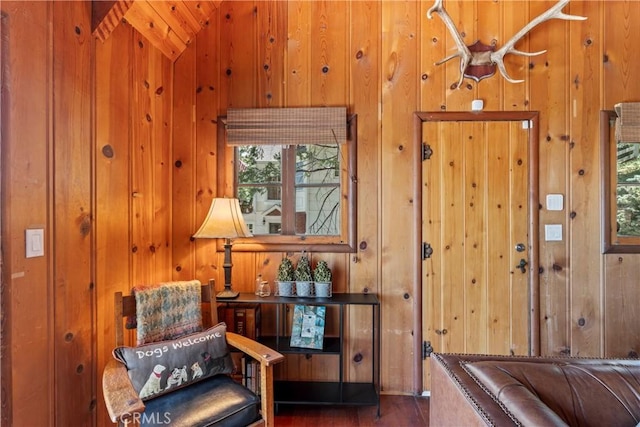 entryway with dark hardwood / wood-style floors and wooden walls