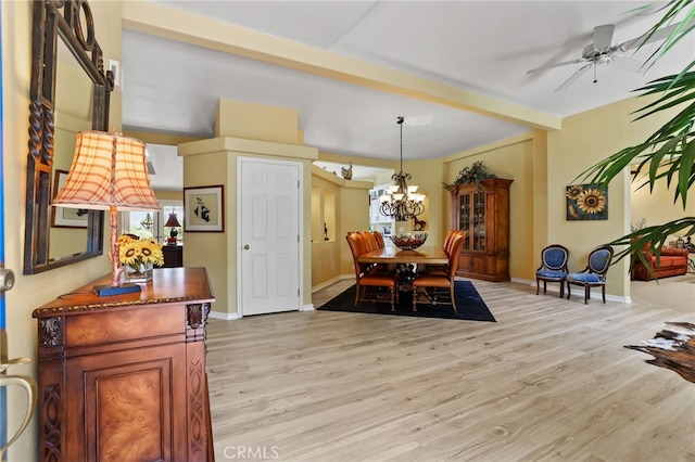 dining room featuring a healthy amount of sunlight, ceiling fan with notable chandelier, and light wood-type flooring