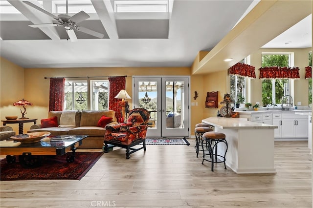 living room with light hardwood / wood-style floors, french doors, ceiling fan, and a wealth of natural light