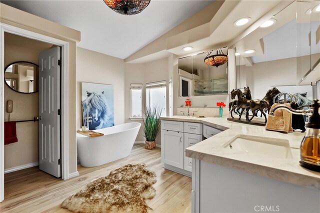 bathroom featuring vanity, hardwood / wood-style floors, separate shower and tub, and vaulted ceiling