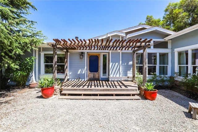 back of house with a wooden deck and a pergola