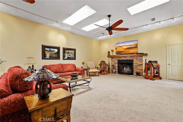 living room featuring a fireplace, carpet flooring, rail lighting, and ceiling fan