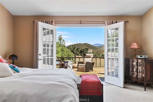 bedroom featuring french doors, a mountain view, multiple windows, and carpet floors