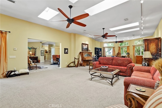 living room featuring rail lighting, light colored carpet, and ceiling fan