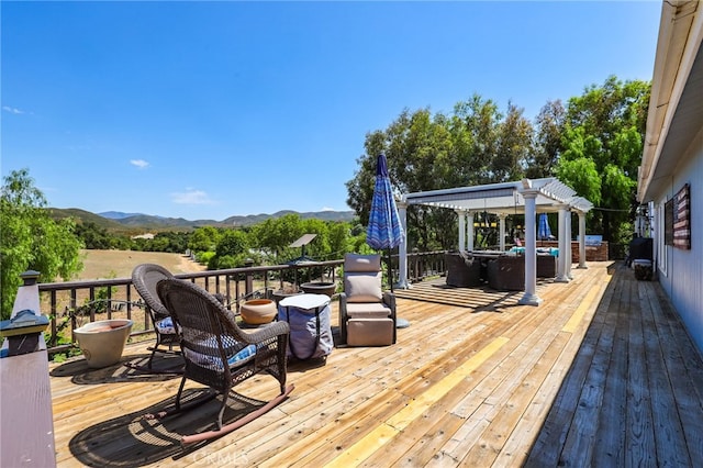 wooden deck featuring a mountain view and a pergola