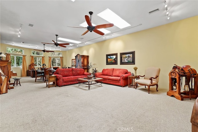 living room with rail lighting, light colored carpet, a skylight, and ceiling fan