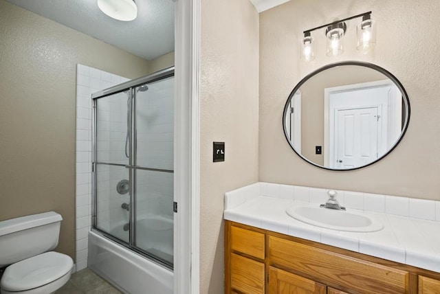 full bathroom with vanity, bath / shower combo with glass door, and toilet