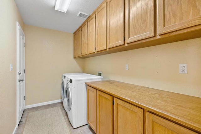 laundry room featuring cabinets, washer and dryer, and light tile patterned floors