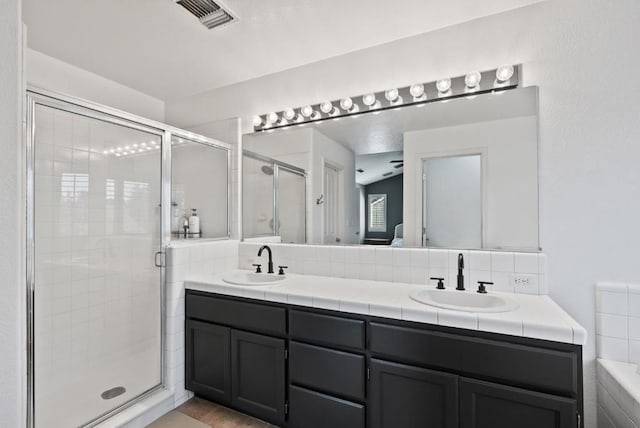 bathroom featuring vanity, walk in shower, and tile patterned flooring