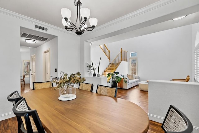 dining space featuring a wealth of natural light, crown molding, and hardwood / wood-style flooring