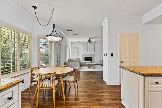 dining area with ornamental molding, dark wood-type flooring, and ceiling fan