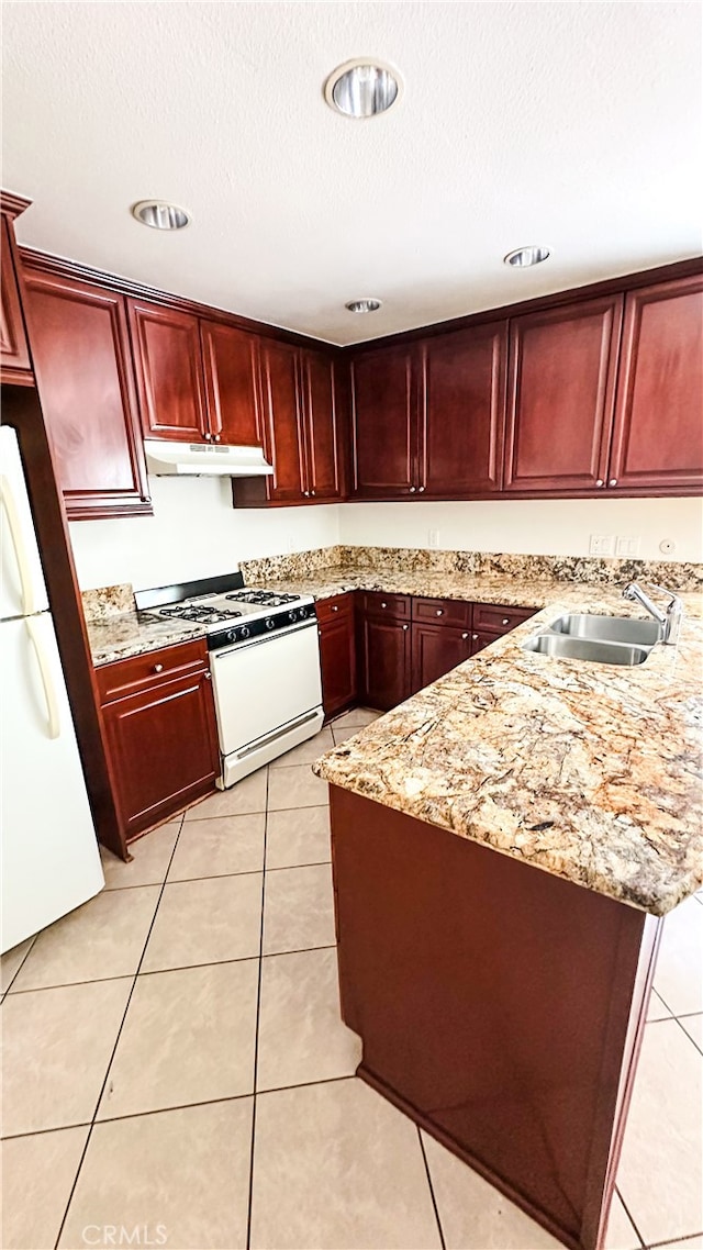 kitchen with light stone countertops, white appliances, sink, and light tile patterned floors