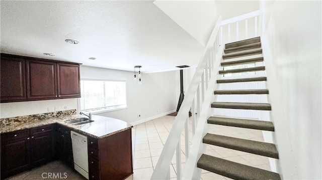 kitchen featuring light stone countertops, light tile patterned floors, white dishwasher, decorative light fixtures, and sink