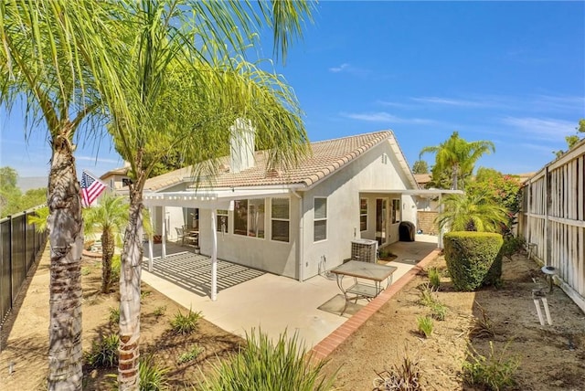 rear view of house featuring a pergola and a patio area