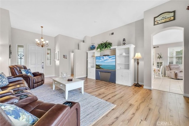 living room with an inviting chandelier and light hardwood / wood-style flooring