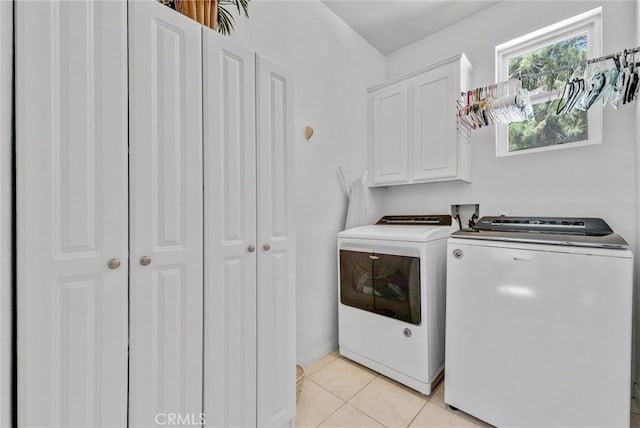 laundry area with cabinets, separate washer and dryer, and light tile patterned floors