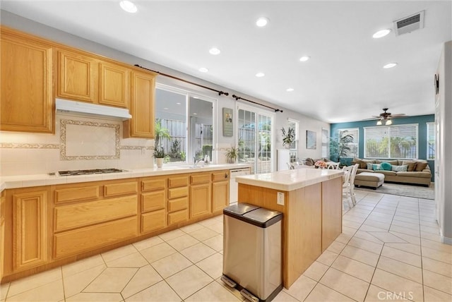 kitchen featuring ceiling fan, white dishwasher, light tile patterned floors, and a kitchen island