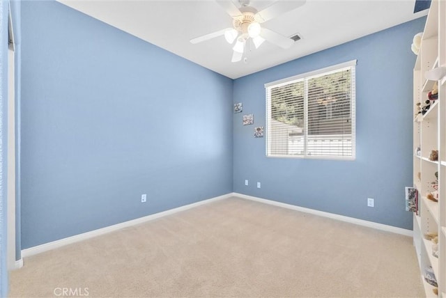 carpeted spare room featuring ceiling fan