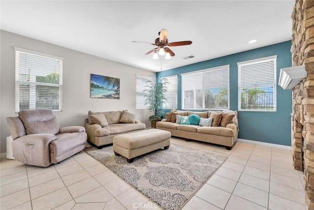 tiled living room with plenty of natural light, ceiling fan, and a fireplace