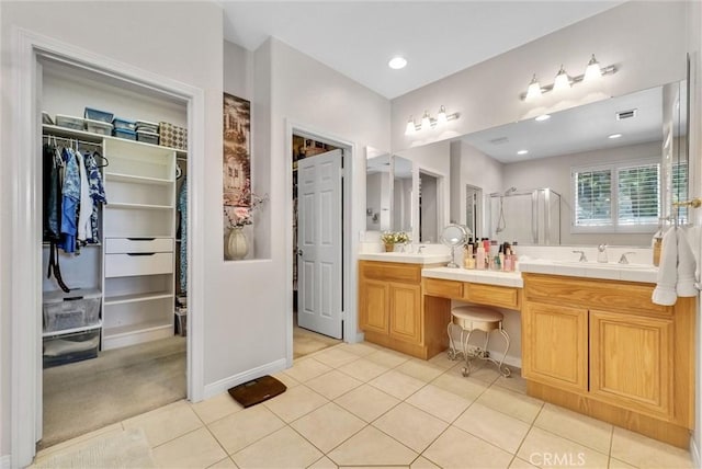 bathroom featuring tile patterned flooring, vanity, and a shower with shower door