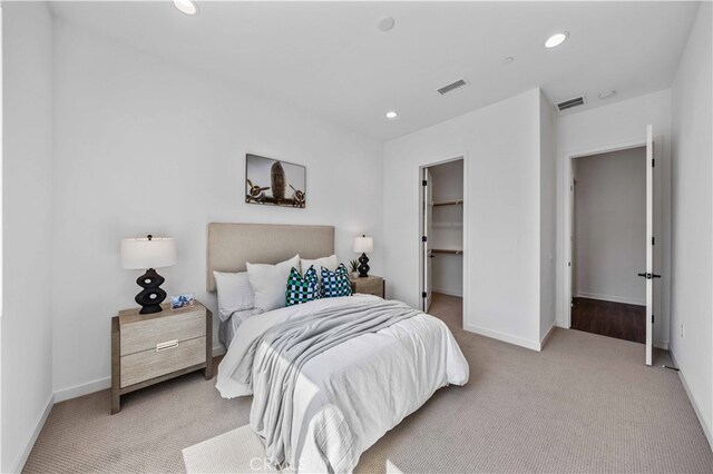 carpeted bedroom with a closet and a walk in closet