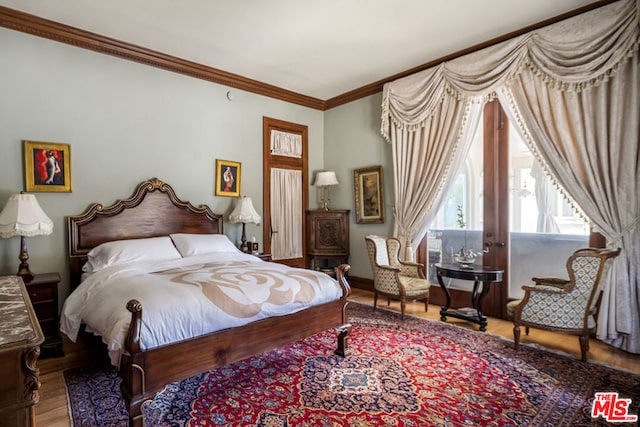 bedroom featuring ornamental molding and hardwood / wood-style floors