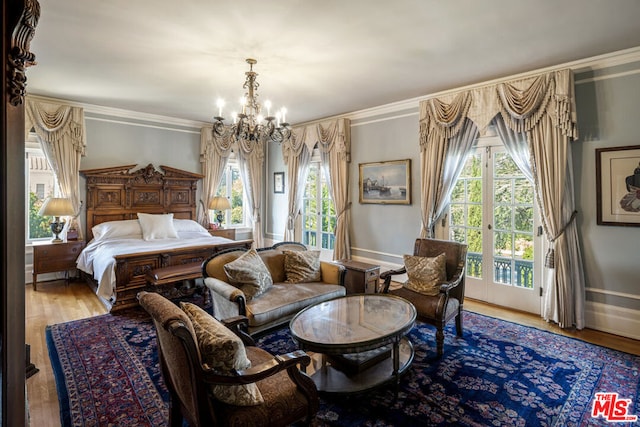 bedroom featuring wood-type flooring, ornamental molding, a notable chandelier, and access to exterior