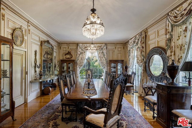 dining area featuring crown molding, an inviting chandelier, and light hardwood / wood-style flooring