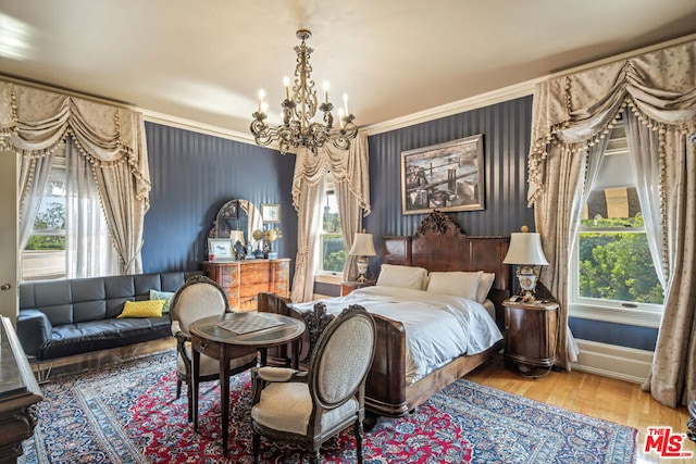 bedroom with hardwood / wood-style flooring, a notable chandelier, and multiple windows