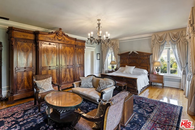 bedroom with ornamental molding, light wood-type flooring, and a chandelier