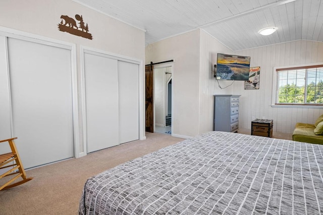 carpeted bedroom featuring vaulted ceiling, a barn door, wood ceiling, and wood walls