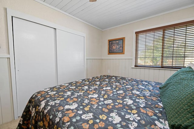 carpeted bedroom featuring crown molding, wood walls, a closet, and wood ceiling