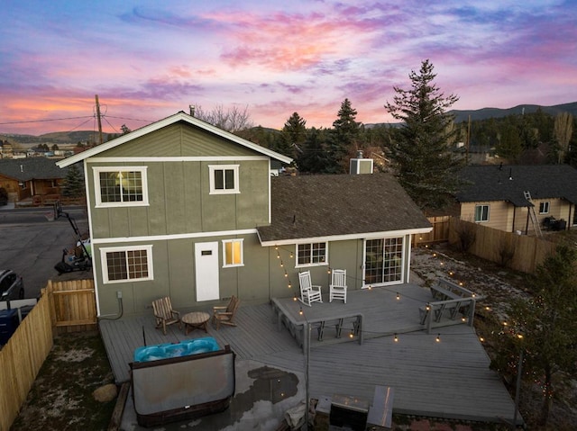 back house at dusk with a wooden deck