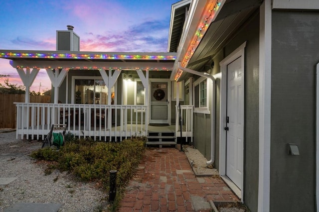 back house at dusk with covered porch