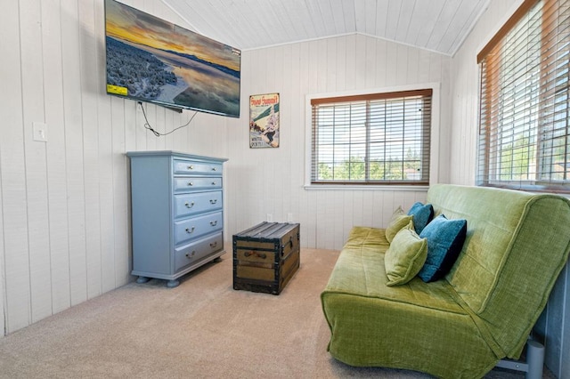 living area with light carpet, wood walls, and vaulted ceiling