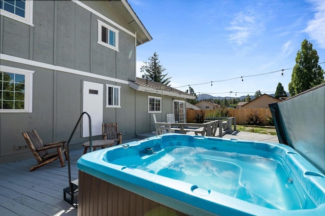 view of swimming pool with a hot tub and a deck