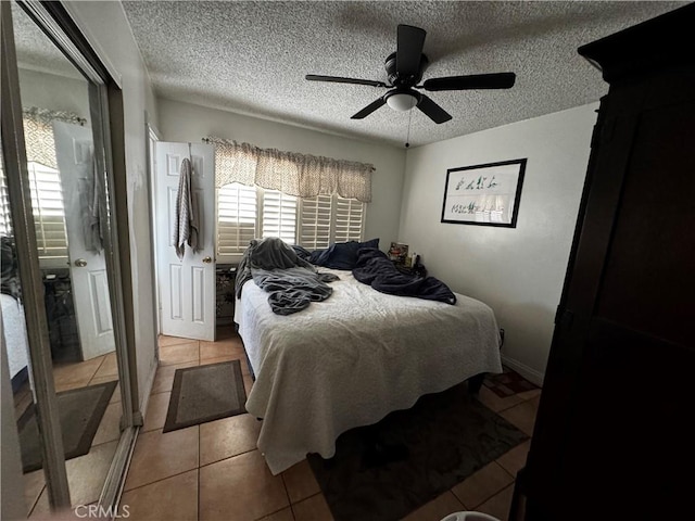 bedroom with a textured ceiling, multiple windows, and light tile patterned floors