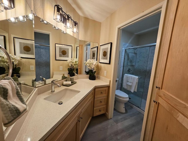 bathroom featuring a shower with shower door, hardwood / wood-style floors, toilet, and vanity