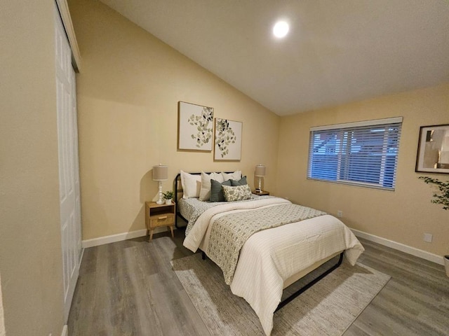 bedroom featuring vaulted ceiling, dark hardwood / wood-style flooring, and a closet