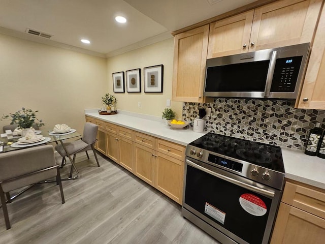 kitchen with decorative backsplash, crown molding, light wood-type flooring, light brown cabinets, and stainless steel appliances