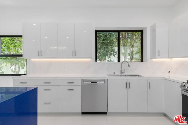 kitchen with white cabinetry, dishwasher, sink, tasteful backsplash, and light tile patterned flooring