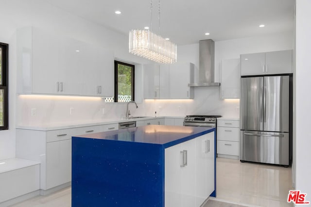 kitchen with white cabinetry, a center island, hanging light fixtures, stainless steel appliances, and wall chimney range hood