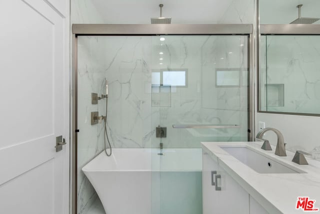 bathroom with vanity and shower with separate bathtub