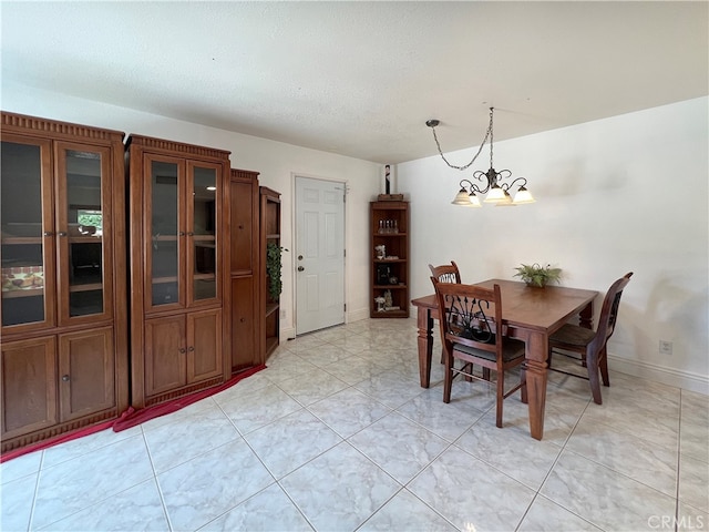 dining area featuring a notable chandelier and light tile patterned flooring