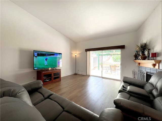 living room with light hardwood / wood-style floors and vaulted ceiling