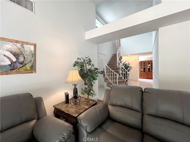 tiled living room with a towering ceiling